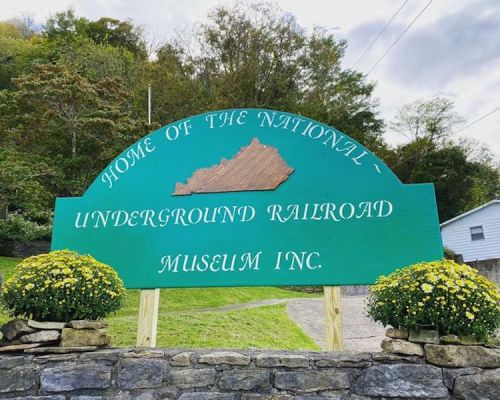 Sign for the National Underground Railroad Museum Inc., featuring a map of Kentucky and surrounded by flowers.