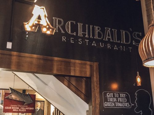 Signage for Archibald's Restaurant, featuring vintage-style letters and warm lighting in a cozy interior.
