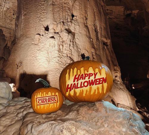 Two pumpkins in a cave, one with "Happy Halloween" and the other labeled "Natural Bridge Caverns."
