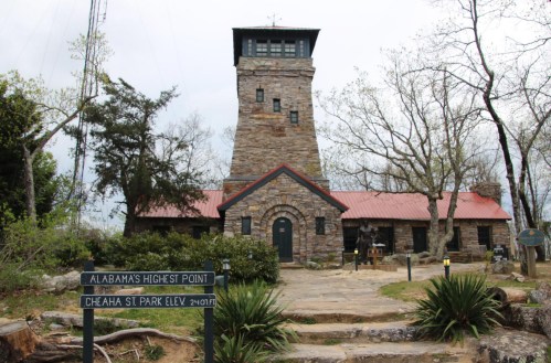 Stone tower and building at Cheaha State Park, Alabama's highest point, surrounded by trees and greenery.