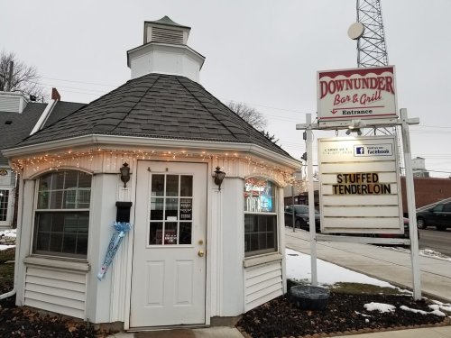 A cozy restaurant with a round structure, festive lights, and a sign advertising "Stuffed Tenderloin."
