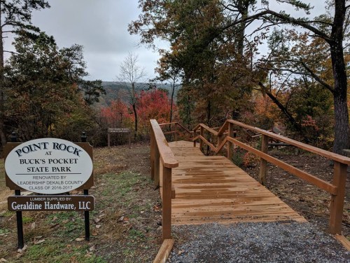 Wooden walkway leading to a scenic overlook at Point Rock, Buck's Pocket State Park, surrounded by autumn foliage.