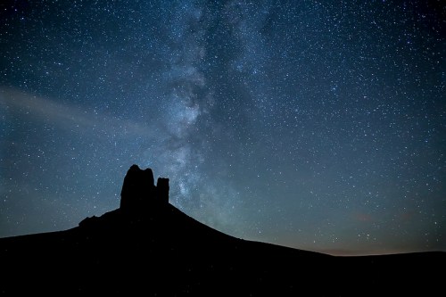 Silhouette of a rock formation against a starry night sky with the Milky Way visible.