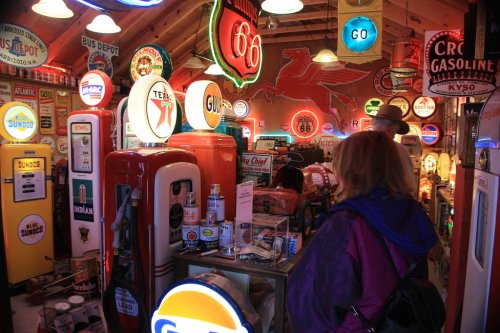 A vintage gas station display filled with colorful neon signs, gas pumps, and nostalgic memorabilia.