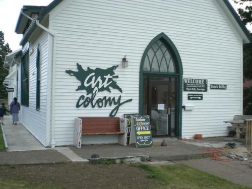 Exterior of a building labeled "Art Colony," featuring a welcoming entrance and signage.