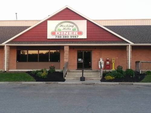Exterior view of Hocking Hills Diner, featuring a red and beige building with a sign and landscaped entrance.