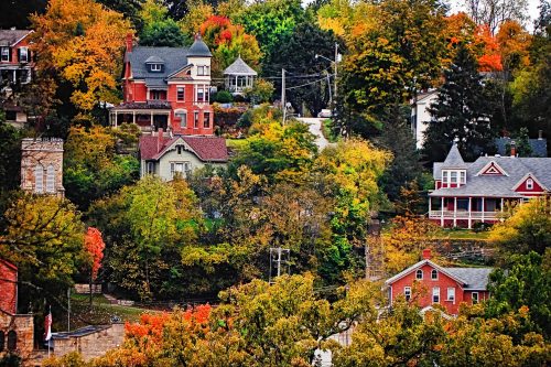 A scenic view of colorful autumn trees and charming houses on a hillside.
