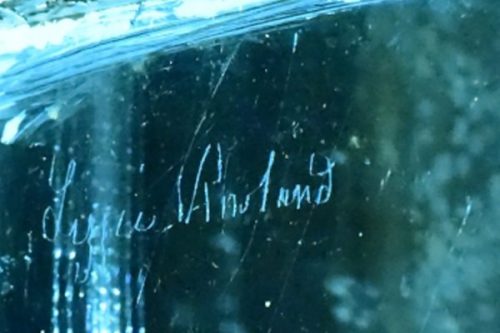 Close-up of an engraved signature that reads "Lissie V. Holland" on a reflective surface.