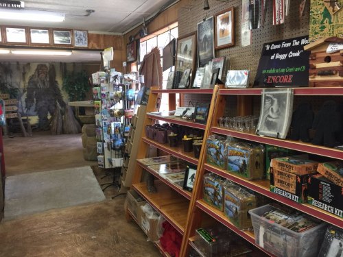 Interior of a gift shop featuring shelves of merchandise, including postcards, souvenirs, and Bigfoot-themed items.