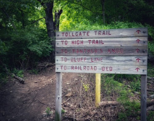 Wooden trail sign with directions to Tollgate Trail, High Trail, Panther's Knob, Bluff Line, and Railroad Bed.