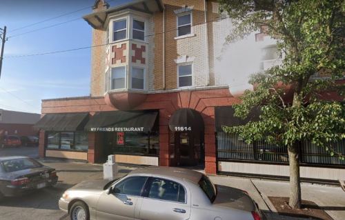Exterior view of "My Friend's Restaurant," a brick building with large windows and a parked car in front.
