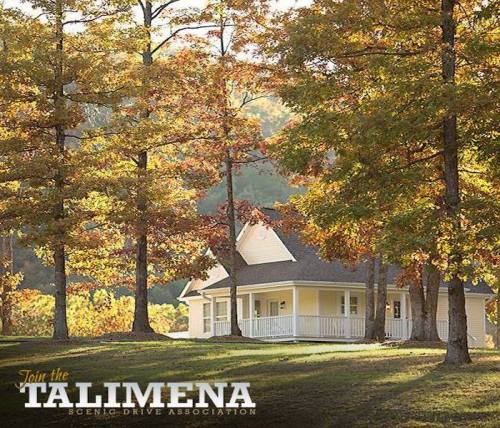 A charming house surrounded by vibrant autumn trees, showcasing colorful fall foliage.