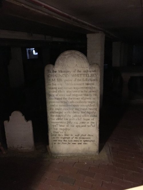 A weathered gravestone in a dimly lit underground setting, honoring Chauncey Whittelsey, dated 1787.