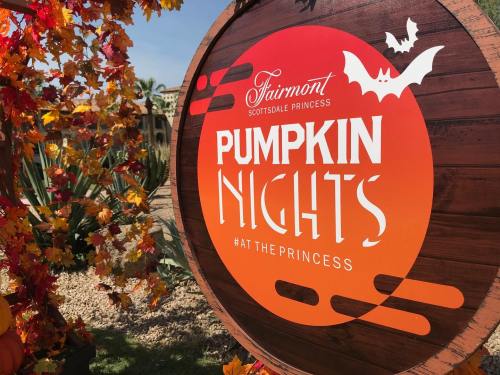 Sign for "Pumpkin Nights" at Fairmont Scottsdale Princess, surrounded by autumn leaves and festive decorations.