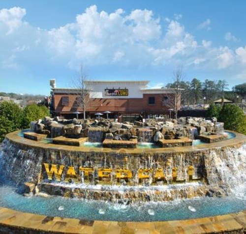 A scenic waterfall feature with rocks and water, featuring the word "WATERFALL" in large letters, under a blue sky.
