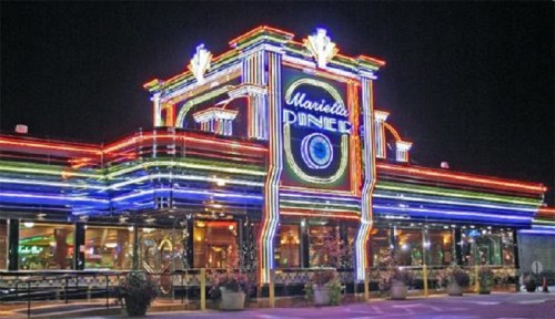 A brightly lit diner with colorful neon lights and a retro design, showcasing its name prominently.