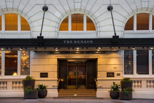 The entrance of The Benson hotel, featuring elegant architecture and welcoming lights.