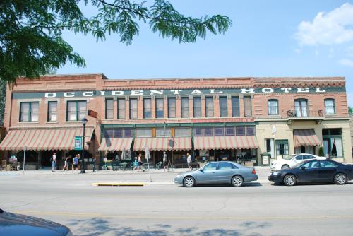 Historic Occidental Hotel with striped awnings, bustling street scene, and clear blue sky.