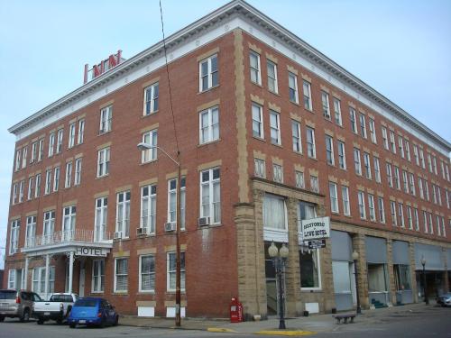 Historic brick hotel building with large windows and a prominent sign, located on a street corner.