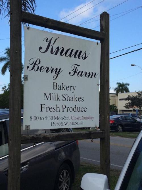Sign for Knaus Berry Farm featuring bakery, milk shakes, and fresh produce. Open 8 AM to 5:30 PM, closed Sunday.