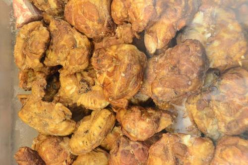A close-up of golden-brown fried chicken pieces piled together in a container.