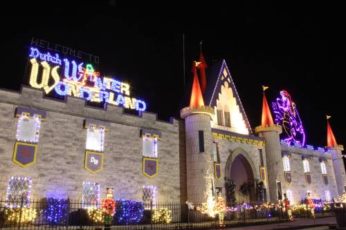 A brightly lit castle with colorful holiday decorations and a sign reading "Welcome to Winter Wonderland."