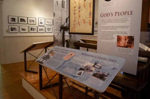 Exhibit display featuring historical photos and information about mission churches and God's people in a museum setting.