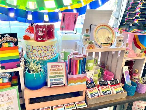 A colorful display of various decorative items, including mugs, plants, and stationery, in a bright shop setting.
