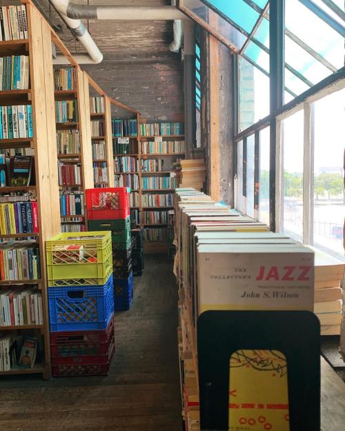 A cozy bookstore interior with shelves of books and colorful crates, featuring a prominent jazz collection.