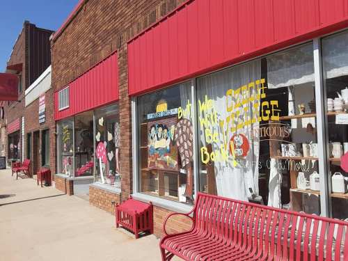A storefront with large windows displaying colorful merchandise and a sign that reads "We have great vintage books!"