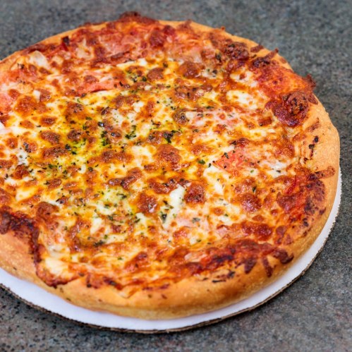 A freshly baked pizza with melted cheese, pepperoni, and a golden crust on a gray countertop.