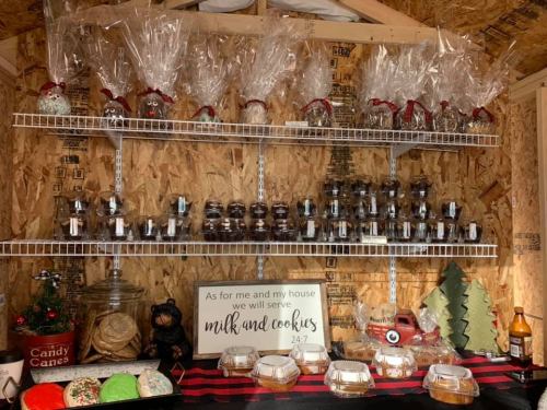 A festive display of cookies and treats on shelves, with a sign that reads "As for me and my house we will serve milk and cookies."