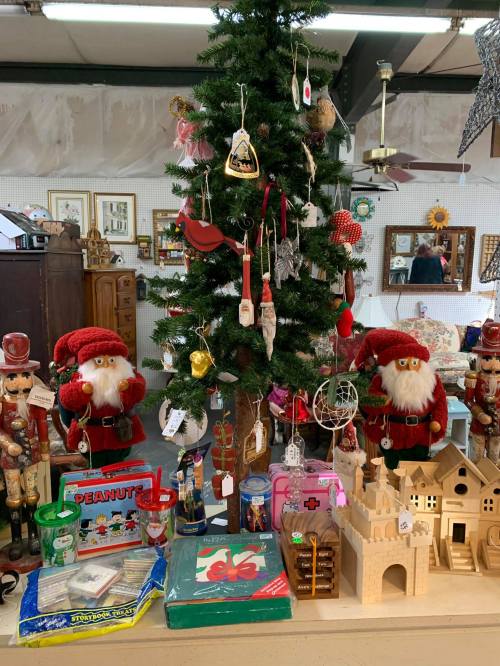 A festive display featuring a decorated Christmas tree, nutcracker figures, and various holiday-themed items.