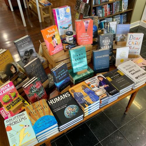 A display of various books on a table in a bookstore, featuring colorful covers and titles.