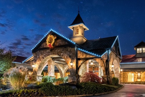 A beautifully lit stone building at night, adorned with holiday decorations and a starry sky above.