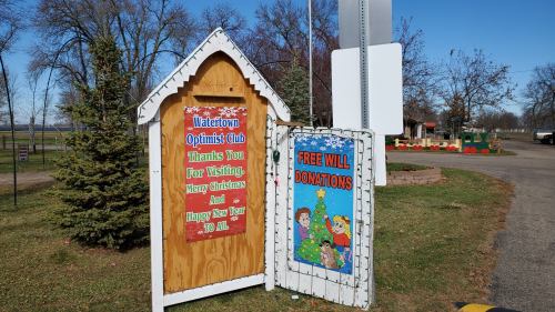 Signage for the Watertown Optimist Club, wishing Merry Christmas and Happy New Year, with a donation request.
