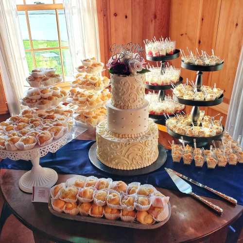 A beautifully arranged dessert table featuring a tiered wedding cake, cupcakes, and assorted sweet treats.