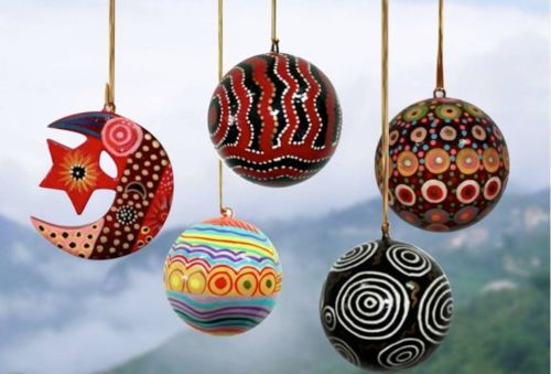Colorful decorative ornaments in various shapes and patterns, hanging against a misty background.