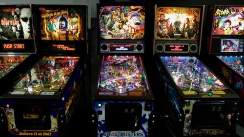 Three colorful pinball machines featuring themes from "Ghostbusters," "Game of Thrones," and "The Sopranos."