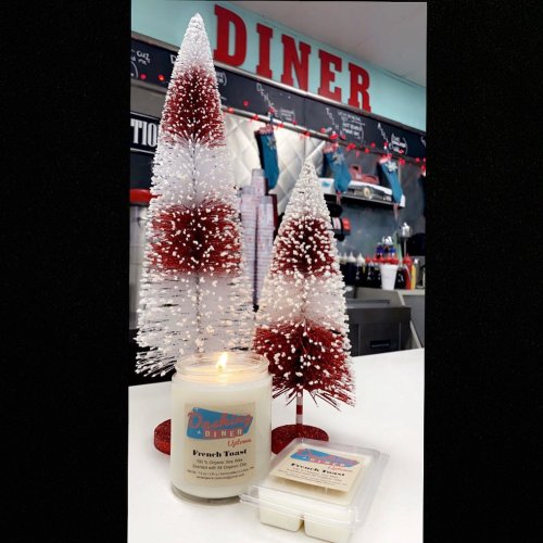 A lit candle labeled "French Toast" beside two decorative snowy trees in a diner setting.