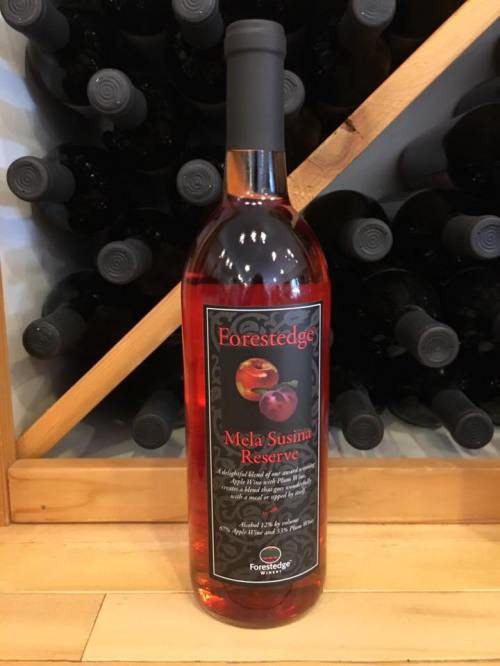 A bottle of Forestedge Mela Susina Reserve wine, displayed against a backdrop of wine bottles.