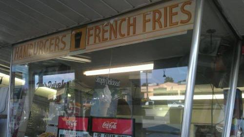 Sign for a food stand displaying "Hamburgers" and "French Fries" with a menu and drink options visible.