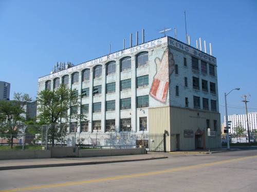 A vintage building with a faded sign for "Used and Rare Books" against a clear blue sky.