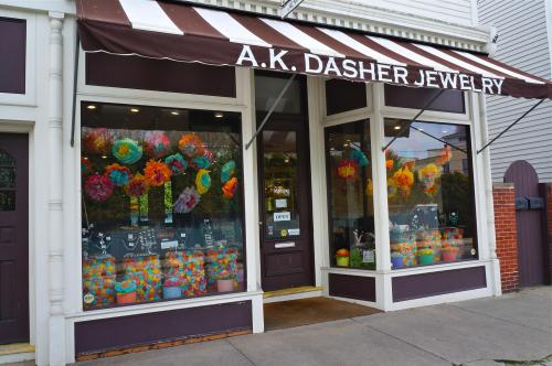 A.K. Dasher Jewelry storefront with colorful decorations and a sign indicating it's open.