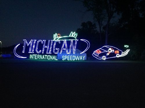 Colorful neon sign for Michigan International Speedway, featuring a car and decorative elements.