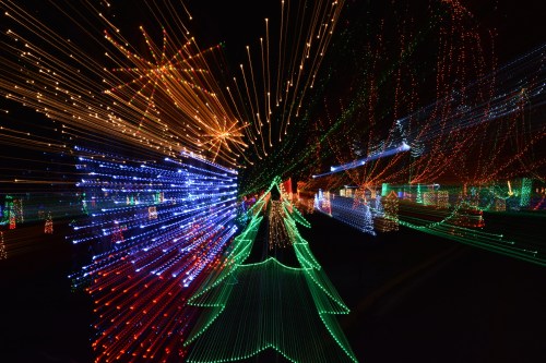 Colorful holiday lights create a vibrant, star-shaped pattern against a dark night sky.