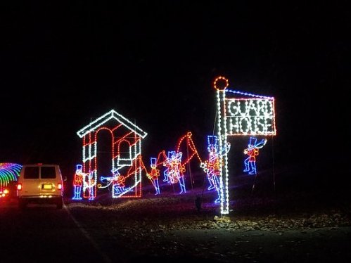 Colorful holiday lights display featuring toy soldiers and a guard house, set against a dark night sky.