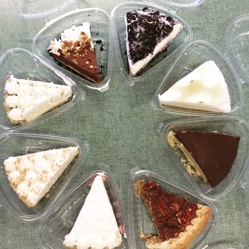 A circular arrangement of various cake slices in clear containers, featuring different flavors and toppings.