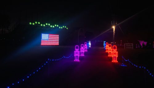 Colorful LED lights display a U.S. flag and illuminated figures in a festive nighttime setting.