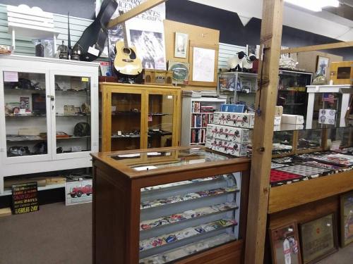 A vintage shop interior featuring display cases, shelves of collectibles, and various memorabilia items.